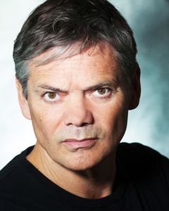 Timothy Watson interpreta Riley