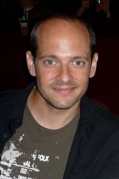 Jonathan Slavin interpreta Tux Shop Employee