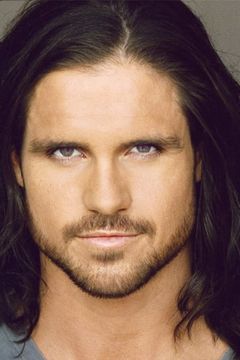 John Hennigan interpreta Adam / Kelso