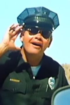 Bill Kangas interpreta Policeman