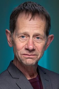 John Warkentin interpreta Warren Hotel Desk Clerk