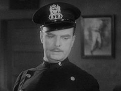 Frank Holliday interpreta Policeman