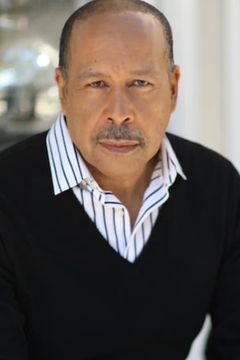 Lance E. Nichols interpreta Senator Abrams
