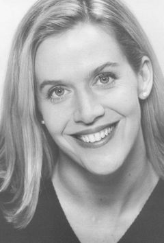 Ellen Savaria interpreta Blonde Television Reporter